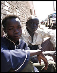 Photo:  Emily Wax/ Washington Post.  Ahmed Abdulraham, 14, left, sits on a street with his friend Fecil Khmis. They are among an estimated 35,000 minors living on the streets of Sudan's capital. 