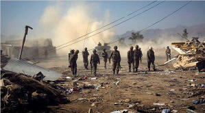 Pakistani soldiers walk down a road in Loe Sam town in Bajaur tribal region. Emilio Morenatti/Pool photo/NYT 