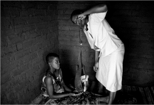 Rosaria Chimwaza, a health survey assistant, weighs a baby girl in a Malawi village as her 18-year-old mother looks on. The rate of decline in child mortality for Malawi and six other countries with the highest rates has been much steeper than the global average, according to an analysis by demographers. Perhaps Malawi's most powerful weapon against child mortality has been its ranks of more than 10,000 high-school-educated village health workers.  Photo: Moises Saman/New York Times