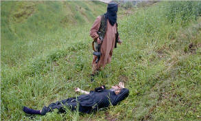 An armed Pakistani Taliban stands beside the body of one of two policemen killed in the Buner district on April 7.  Photo: Reuters