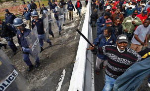 Striking South African municipal workers are monitored by police as they protest in Cape Town. Thousands of municipal workers across the country are into their third day of strikes following a breakdown in wage talks with the South African Local Government Assn. Photo: Nic Bothma / EPA