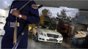 A security guard standing at the entrance of a Mercedes Benz dealer in Islamabad. Photo: Kuni Takahashi/New York Times