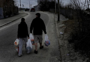 Photo of man and wife waling home with bags of groceries. Rhode Island town relies on food stamps: In Woonsocket, R.I., a third of the residents use SNAP, formerly known as food stamps, to pay for groceries. That means the businesses in the struggling town also rely on the program to survive. Photo: Michael S. Williamson/Washington Post