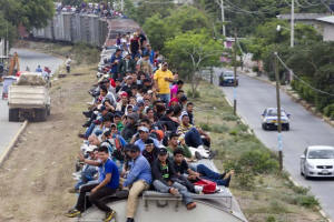 Dozens of Central American migrants riding through Mexico on the roof of a freight train