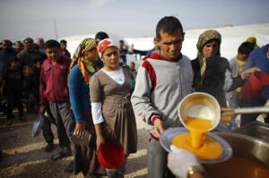 Kurdish refugees from the Syrian town of Kobani queue to get food in a camp in the southeastern town of Suruc, Sanliurfa province, November 13, 2014. Photo: REUTERS/Osman Orsal