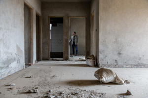 Picture of man standing in an unfinished apartment. Photo: Graham Crouch for The New York Times