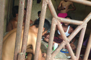 Thai and Burmese fishing boat workers sit inside a cell at the compound of a fishing company in Benjina, Indonesia on Nov. 22, 2014. The imprisoned men were considered slaves who might run away. Photo: Dita Alangkara/AP